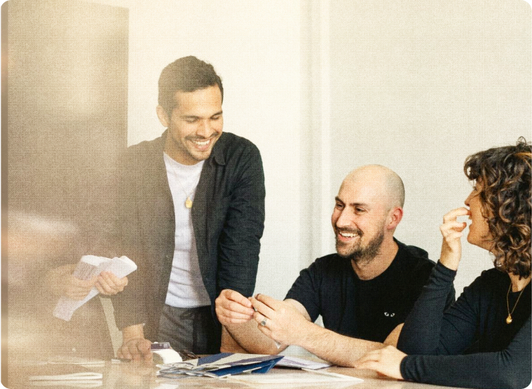 Three colleagues reviewing work together at a table